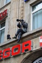 The statue of a photographer sitting on the ledge of the building on a square in Cologne