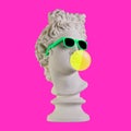 Statue on a pink background. Gypsum statue of Apollo head. Man. Creative. Plaster statue of Apollo head in sunglasses. Minimal Royalty Free Stock Photo