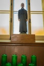 Statue of plaster of a religious in front of a window