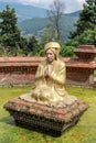 Statue of a praying man in a temple garden with mountain view, Nepal Royalty Free Stock Photo