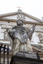 Statue of saint on the background of a medieval church with a cross Royalty Free Stock Photo