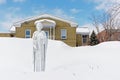 Statue of a saint holding a flower in the snow