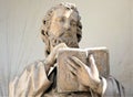 Statue of saint holding and reading holly book