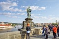 The statue of Saint John of Nepomuk above the bronze plaques thought to bring good luck on Charles Bridge in Prague, Czechia