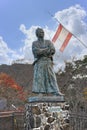 Statue of the samurai Sakamoto RyÃÂma aside the Kaientai flag on the observatory of Kazagashira park.
