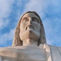 Statue sculpture of Jesus Christ the Savior. Background of blue sky and white clouds. Royalty Free Stock Photo