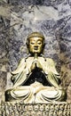 A statue of a seated Buddha is positioned on a patterned base. Royalty Free Stock Photo