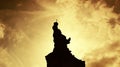 Statue silhouetted at sunset