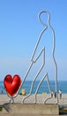 Statue, small architectural forms of a man carrying a heart