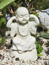 A statue of a small white monk, depicted in a pose of see no evil, hear no evil, speak no evil. Royalty Free Stock Photo
