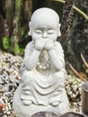 A statue of a small white monk, depicted in a pose of see no evil, hear no evil, speak no evil. Royalty Free Stock Photo