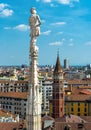 Statue on spire of Milan Cathedral on blue sky background, Milan, Italy. Detail of Gothic roof overlooking Milano city in summer Royalty Free Stock Photo