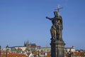 Statue of St. John the Baptist on Charles Bridge, with Hradcany castle and St. Vitus Cathedral in the background, in Prague, Czech Royalty Free Stock Photo