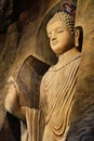 Statue of standing Buddha in monk clothes carved in limestone cave. Royalty Free Stock Photo