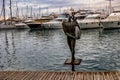 Statue of a surfer in the port of Alicante Spain with pigeons urban landscape
