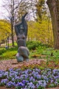 Statue surrounded by flowers in a park