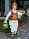 Statue of a tea vendor in a colourful garb and turban with a tea kettle and raising a tea cup Royalty Free Stock Photo