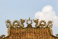 Statue Of Twin Dragons And Moon On Roof Tiles On A Temple.