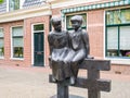 Statue of two orphan children on fence in old town of Bolsward,