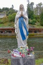 A statue of the Virgin Mary on the banks of the Gave de Pau river in Lourdes