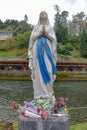 A statue of the Virgin Mary on the banks of the Gave de Pau river in Lourdes