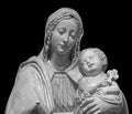 Statue of the virgin Mary carrying the baby Jesus isolated on black background. Mother of god sculpture, classic Royalty Free Stock Photo