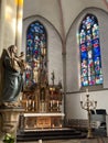 Statue Virgin Mary and Jesus, altar and stained glass windows of the Church of St. Peter and Paul in Ratingen, Germany. Royalty Free Stock Photo