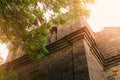 Statue in the wall of an ancient church. View of the building through the branches of a tree Royalty Free Stock Photo