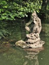 A statue of waterman on a pond in the forest.