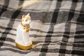Statue of white Egypt cat on checked blanket surface. Traditional egyptian gift element.