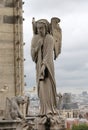 statue of a winged angel above the Notre Dame Cathedral in Paris Royalty Free Stock Photo