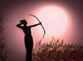 Statue of a woman Archer Silhouette with a bow target the sun.