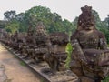 Statues Angkor line asura road trees