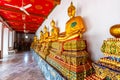 Statues of Buddha in Wat Pho temple, Bangkok Thailand. Golden statues are placed in row in ancient spiritual centre of Buddhism.