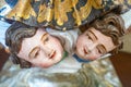 statues representing doll faces at the feet of a saint. Royalty Free Stock Photo