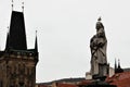 Prague, Czech Republic, January 2015. Statue of a saint with a seagull on his head and a gothic tower.