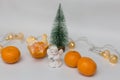 Statuette of an angel on a white background with a Christmas tree, tangerines and garlands