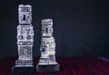 Statuette, Bennett and Ponce monoliths, isolated on a dark lead background.