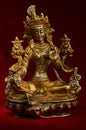 Statuette of Green Tara on a red background. Royalty Free Stock Photo