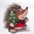 Statuette of a Hedgehog in Christmas red sweater with a Christmas tree