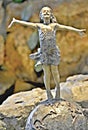 Statuette of a joyful little girl in a rock garden