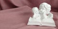 A statuette of little angels reading a book Royalty Free Stock Photo