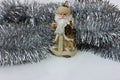 Statuette of Santa Claus on a silver background. Golden santa claus candle isolated on white. Saint Nicholas in beige color with Royalty Free Stock Photo