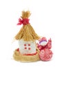 Statuette of a village house with a thatched roof and a rag doll  on a white background Royalty Free Stock Photo