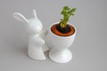 Statuette of a white rabbit with a green carrot sprout.Easter decor