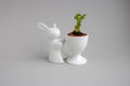 Statuette of a white rabbit with a green carrot sprout.Easter decor