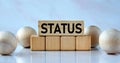 STATUS - word on wooden cubes on a light background with balls