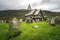 Stave church and cemetery of Roldal in dramatic light on a rainy moody day. Norway. Royalty Free Stock Photo