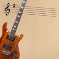 Stave and exotic wood electric guitar on the left side of light skin background. Royalty Free Stock Photo