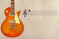 Stave and honey sunburst vintage electric guitar on the left side of rough cardboard background. Royalty Free Stock Photo